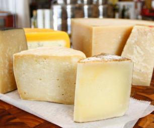 A board with 6 cheeses on it.