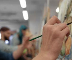Photo of someone painting at a workshop. 