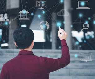 Person stands in front of virtual whiteboard and connects dots between digital symbols 
