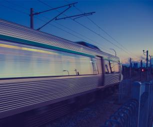 A passenger train in motion at dusk