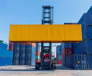 Forklift moving shipping containers at a port