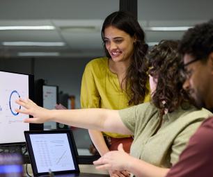Group of diverse people looking at data on a computer screen. 