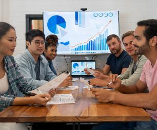 Group of diverse people sitting around a table talking. 