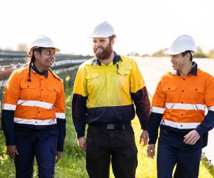 Three workers wearing protective, high visibility clothing