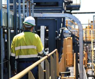 Photo of a construction worker wearing a safety uniform in industrial setting