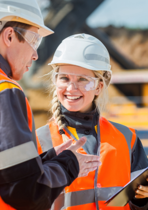 Mine workers talking with mining vehicle in the background