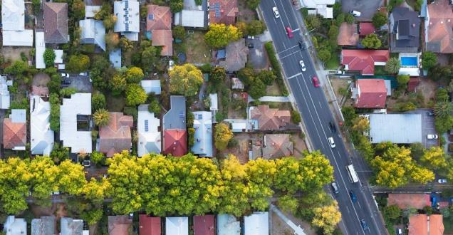 Aerial shot of houses and a road in a suburb.