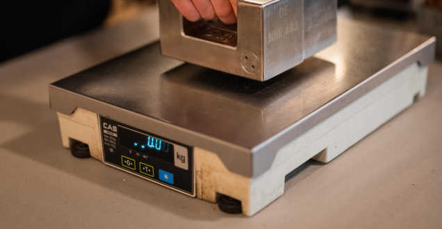 Trade Measurement Officer testing a NAWI (non-automatic weighing instrument) in use for trade. 