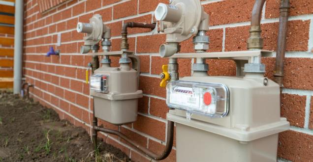 Photo of 2 gas meters fixed to a red brick wall