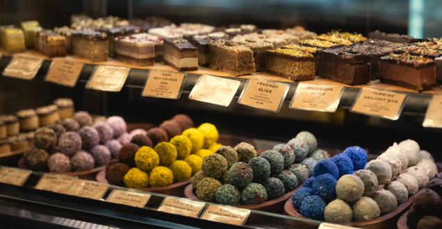 A selection of cakes and patisseries items for sale behind a glass counter