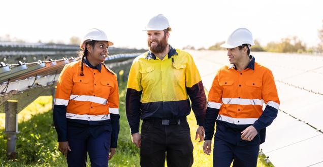 Three workers wearing protective, high visibility clothing