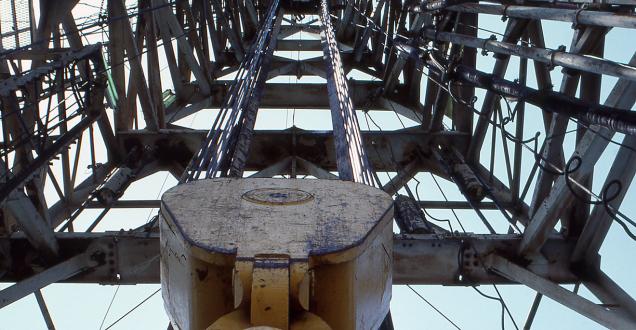 Photo of offshore petroleum infrastructure, looking upward through scaffolding toward the sky.