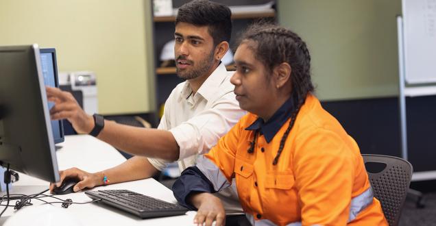 Engineer and apprentice working together in an office.