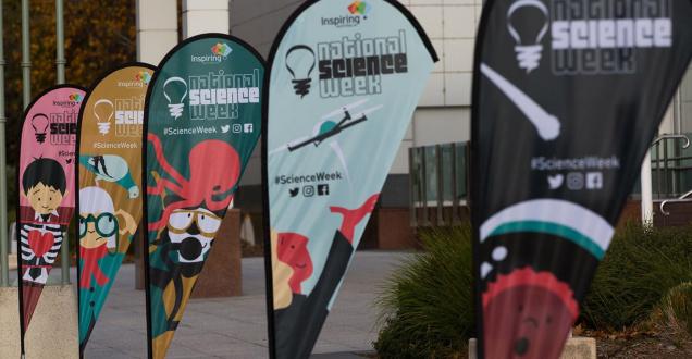 Flags showing various cartoons for National Science Week outside Questacon