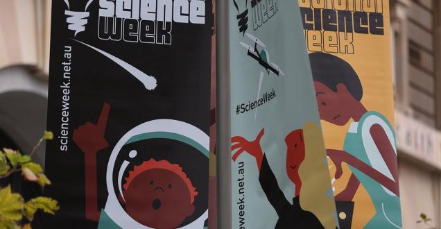 Three National Science Week Questacon flags showing 3 of their science activities cartoon characters.