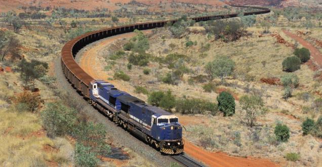 One of the world's longest and heaviest trains carries a load of Pilbara iron ore to port through a rugged desert landscape in outback Western Australia.