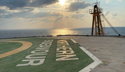 Photo of a platform on the Northern Endeavour with the logo and ocean in the background. 