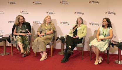 Four people speaking at a conference.