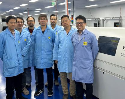 Photo of team in lab standing in front of the oven