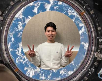 A young man smiling and displaying ‘peace fingers’.