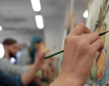 Photo of someone painting at a workshop. 