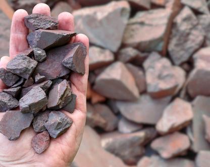 Image of a hand holding pieces of high-grade Australian iron ore.