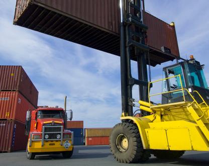 Image of a loaded container handler moving a shipping container