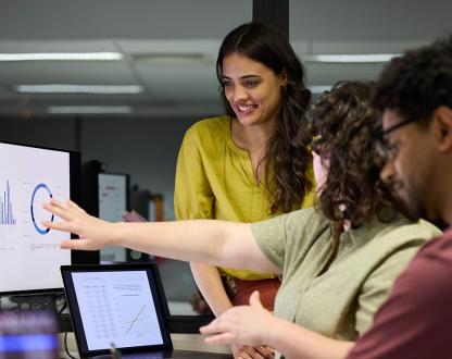 Group of diverse people looking at data on a computer screen. 