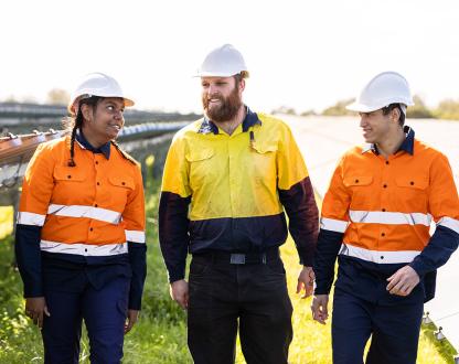 Three workers wearing protective, high visibility clothing