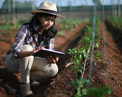 Closeup photo of a farm worker using digital tablet in greenhouse.
