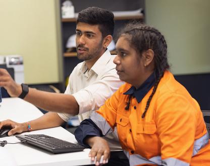 Engineer and apprentice working together in an office.