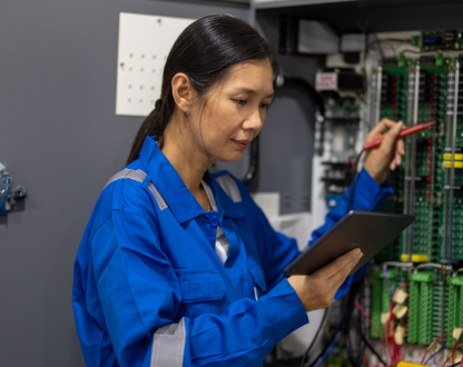 Photo of an IT technician in casual clothing using a digital tablet for work in a server room