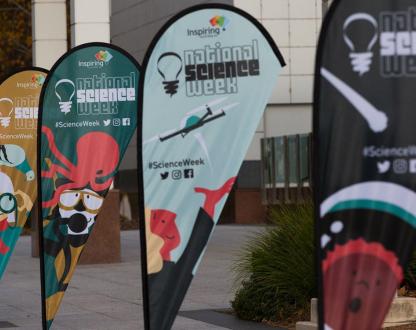 Flags showing various cartoons for National Science Week outside Questacon