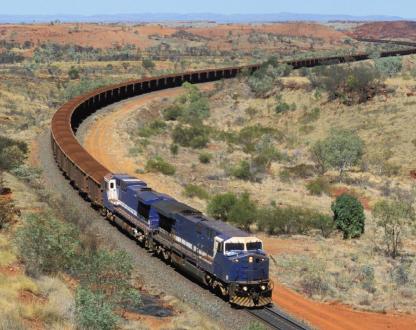 One of the world's longest and heaviest trains carries a load of Pilbara iron ore to port through a rugged desert landscape in outback Western Australia.