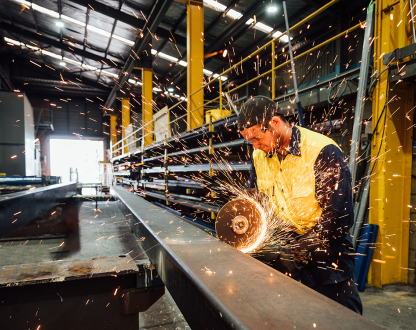 Welder manufacturing goods in a factory
