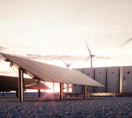 Solar panels in front of a wind farm