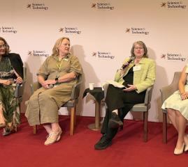 Four people speaking at a conference.