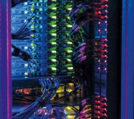 Stacked computer hardware in a case with different coloured lights and wiring