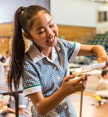 Photo of a primary school girl performing a physics experiment involving wood, strong and PVC pipe