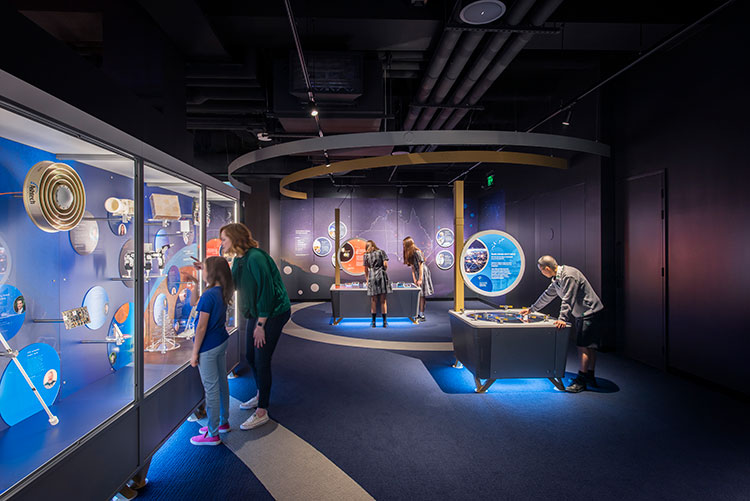 A space exhibition with school children looking around the room.
